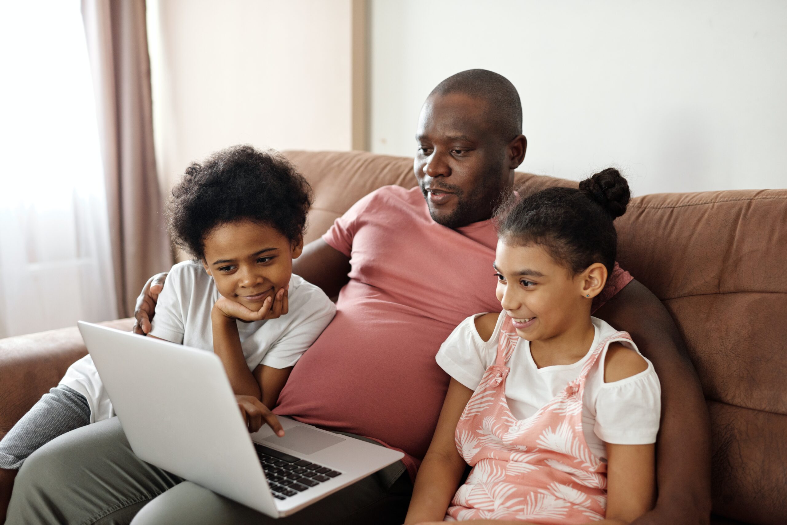 father-and-children-looking-at-a-laptop-4260749